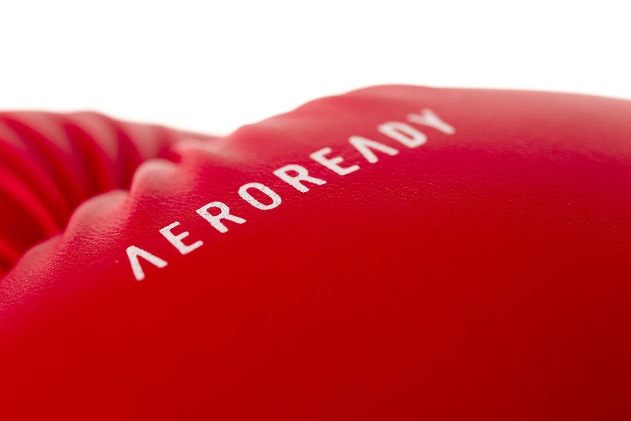 Macro view of red ADIDAS Hybrid25 glove with AEROREADY branding, emphasizing sweat-wicking material.
